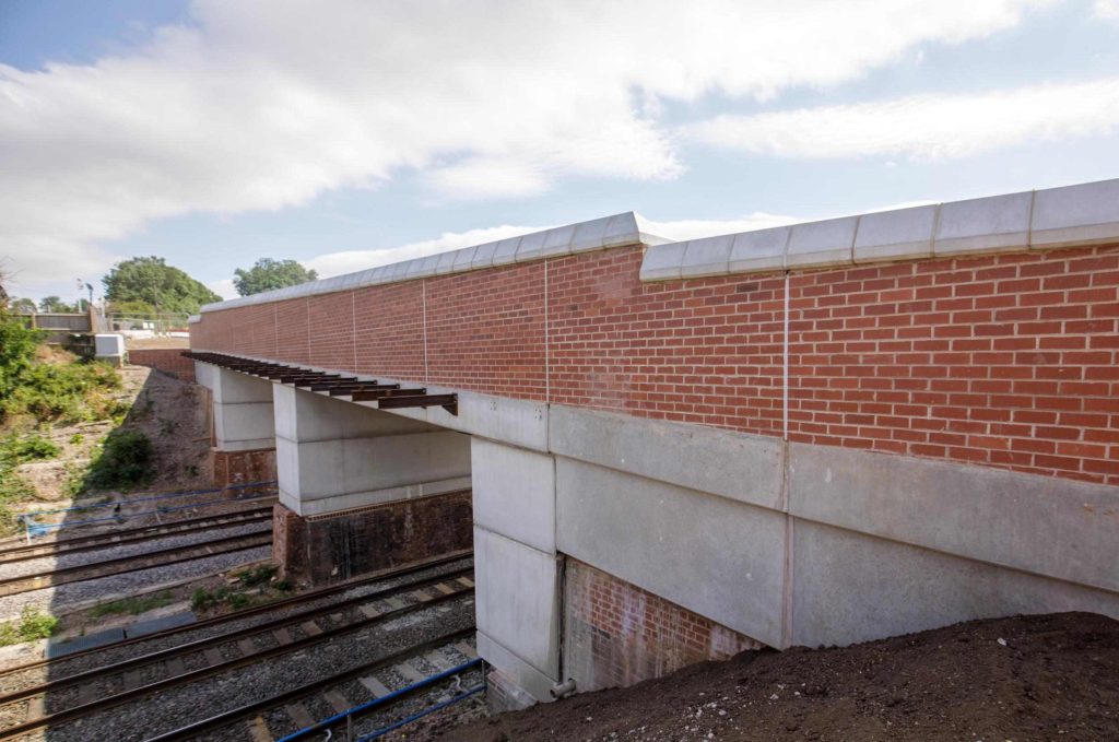 Newly constructed concrete and brick railway bridge spanning the tracks